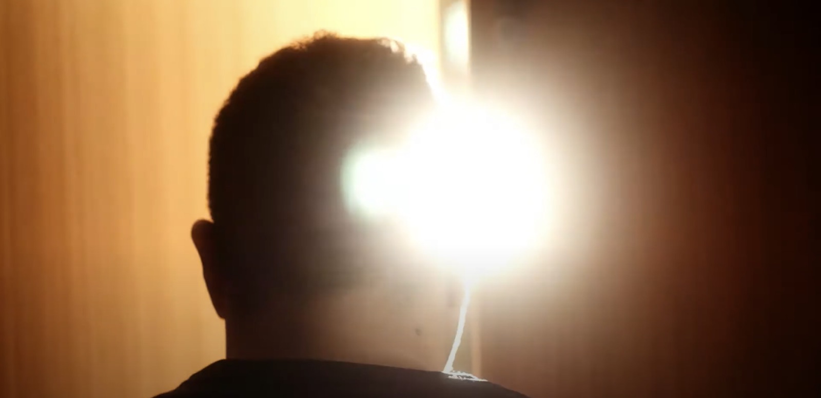 Silhouette of a man against a blown-out light