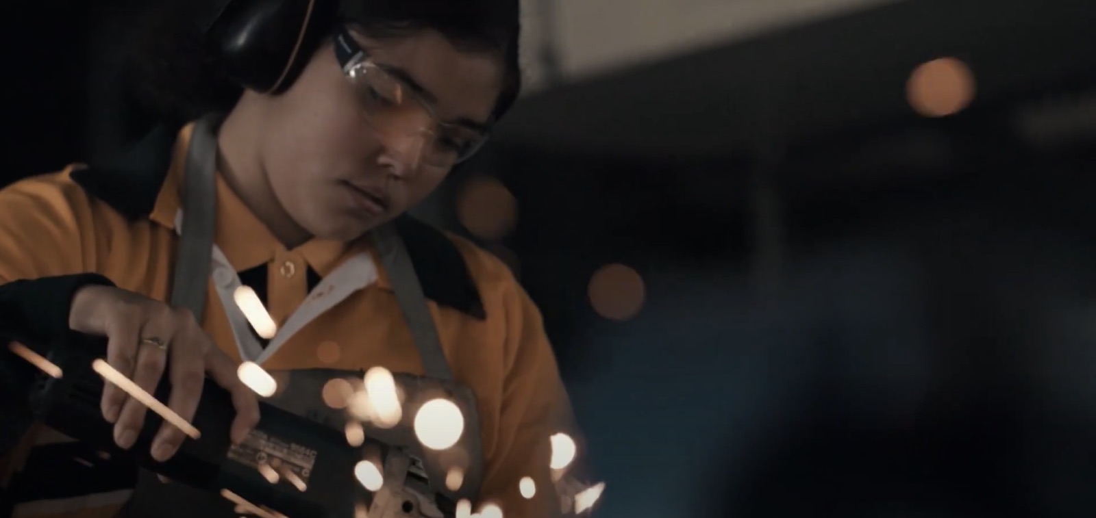 Student in safety glasses grinding metal